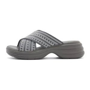 Side view of gray platform wedge sandals featuring crisscross knit straps and wave sole