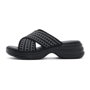 Side view of black platform slide sandals featuring geometric grey woven cross-straps