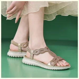Detailansicht goldener Sandalen mit glitzernden Strasssteinen und weißer dicker Sohle