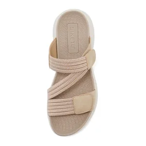 Bovenaanzicht van beige sportsandalen met elastische banden en klittenbanddetail