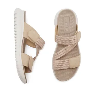 Detail van beige sportieve sandalen met verstelbare kruisbanden en dikke rubberen zool