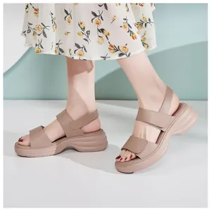 Side view of beige platform wedge sandals with matte leather straps on model