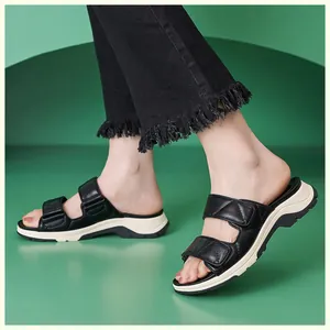 Primer plano de sandalias con plataforma negras con tiras acolchadas y suela blanca