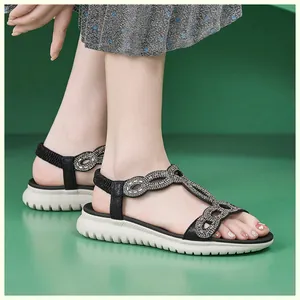 Seitenansicht der Damen-Sandalen mit Strasssteinen, T-Riemen und weißer Gummisohle