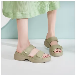 Dettaglio di ciabatte con zeppa verde avocado da donna con cinturini in velcro