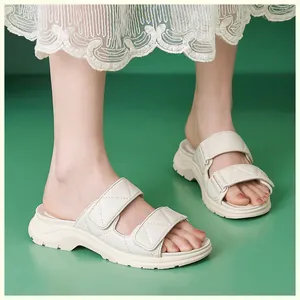 Detalle de sandalias de plataforma crema con correas acolchadas y cierre de velcro