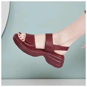 Side view of woman wearing burgundy platform sandals with wave-textured wedge soles