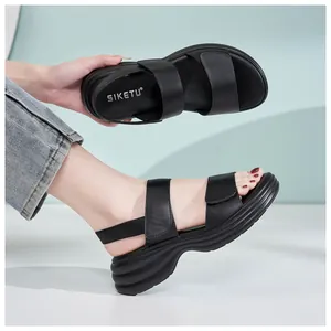 Close-up of black platform sandals featuring textured wavy soles and Velcro straps