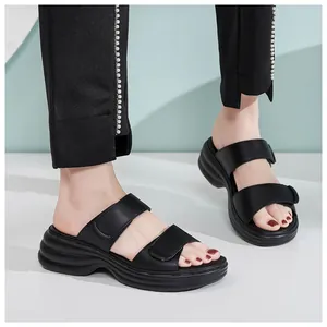 Dettaglio di sandali neri con plateau con doppia fascia regolabile e chiusure in velcro comode