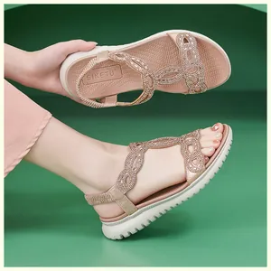 Detailansicht der roségoldenen Sandalen mit funkelnden Straßsteinen und weißer Sohle