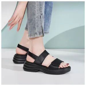 Detailed side view of black platform sandals with velcro straps and wavy wedge soles