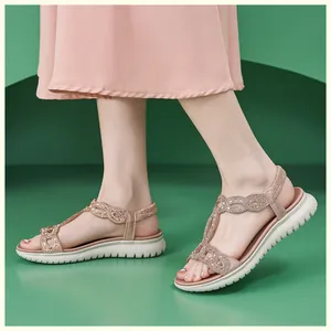 Nahaufnahme der roségoldenen Sandalen mit Strass-T-Riemen und weißer Plateausohle