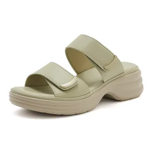Dettaglio ravvicinato dei sandali con plateau in pelle verde salvia e velcro