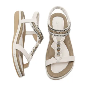 Women's white T-strap flat sandals with beaded elastic ankle strap for beach wear