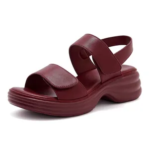 Close-up of dark red platform sandals featuring textured leather and velcro straps