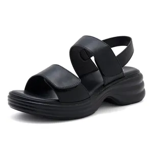 Detail view of women's black platform sandals with velcro straps and wavy sole texture