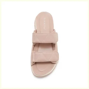 Primer plano de sandalias rosa nude con costuras geométricas y cierre de velcro