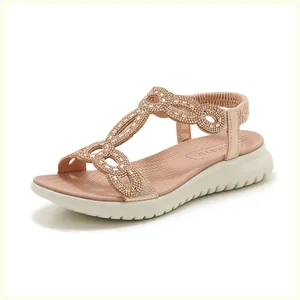 Makroansicht roségoldener Sandalen mit Strassriemen und dicker weißer Wellensohle