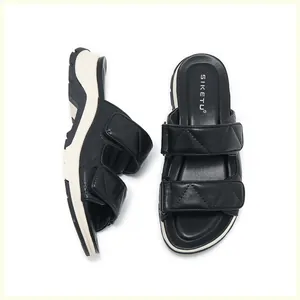 Detalle de sandalias negras con plataforma, correas acolchadas y cierre de velcro