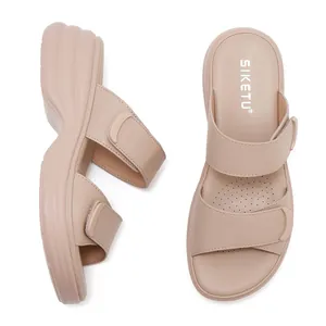 Dettaglio di sandali beige con zeppa dotati di cinturini in velcro e supporto plantare