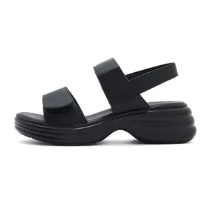 Detailed side view of black platform sandals with wave textured soles and velcro straps