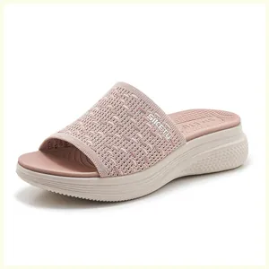 Detail of breathable knitted upper and thick non-slip wedge sole on pink comfort slide
