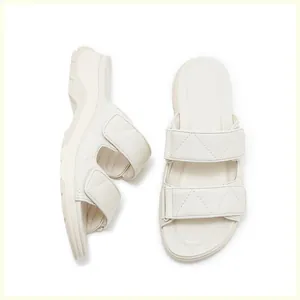 Detalle de sandalias de plataforma crema con tiras acolchadas y cierre de velcro