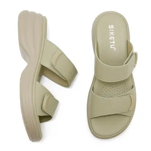 Dettaglio di sandali con zeppa verde chiaro con cinturini in velcro e cuciture rifinite