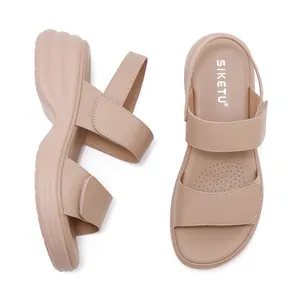 Macro view of beige platform sandals with adjustable hook and loop straps and breathable insole