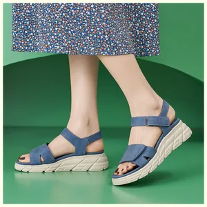 Detail von marineblauen Plateausandalen mit Klettverschluss und floralem Rock