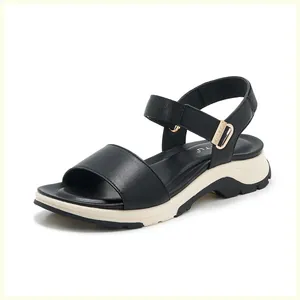 Detail view of adjustable buckle and thick platform sole on black sporty sandals