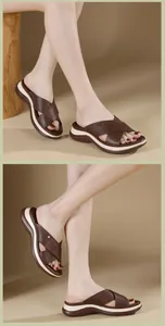 Macro view of women platform slide sandals featuring dark brown cross straps and wedge soles