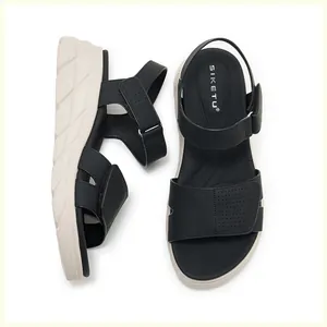 Nahaufnahme schwarzer Plateau-Sandalen mit Klettverschluss und atmungsaktiver Perforation