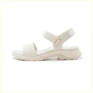 Detail view of the thick platform sole and adjustable velcro strap on ivory sport sandals