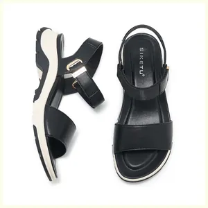 Macro view of women's black wedge sandals featuring comfortable platform soles and buckled straps