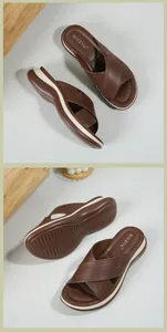 Detailed view of women's brown cross-strap platform slippers with non-slip sole and stitching