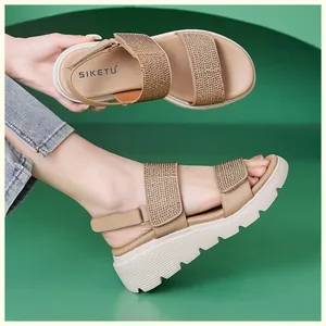 Detailed view of rhinestone-embellished straps and adjustable velcro strap on wedge sandals
