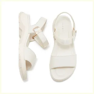 Detail of cream platform sandals with gold buckles and adjustable velcro straps