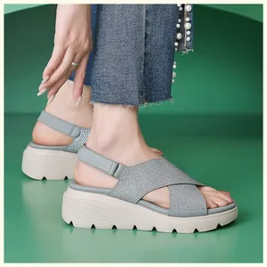 Dettaglio di sandali con zeppa grigio-blu con cinturini in strass e chiusura velcro