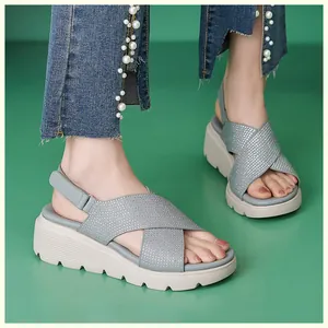 Dettaglio di sandali con zeppa alta con strass scintillanti e cinturini velcro regolabili