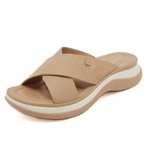 Beige platform slide sandals with crisscross straps and contrast stitching on soft sole