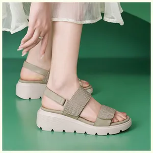 Detail view of sage green wedge sandals featuring sparkling rhinestones and velcro straps