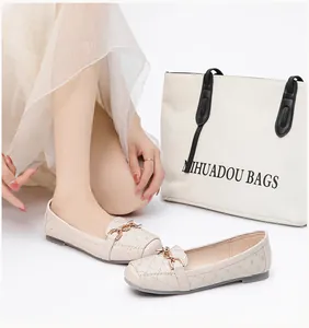 Close-up van gebroken witte gewatteerde ballerina's met vierkante neus en metalen gesp