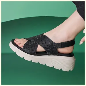 Dettaglio dei sandali platform neri con cinturini in strass e suola bianca spessa