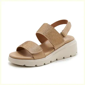 Close-up of sparkling gold rhinestones on beige platform wedge sandals with velcro