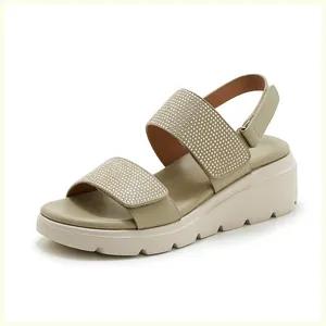 Macro view of sparkly rhinestone straps and thick platform sole on green summer wedge sandals