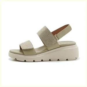 Detail view of rhinestone-embellished straps and platform wedge sole on sandals