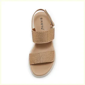 Detail view of champagne gold wedge sandals with glittering rhinestones and velcro strap