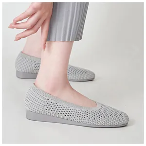 Dettaglio della tomaia in maglia grigia su scarpe con zeppa traspiranti per maggiore comfort