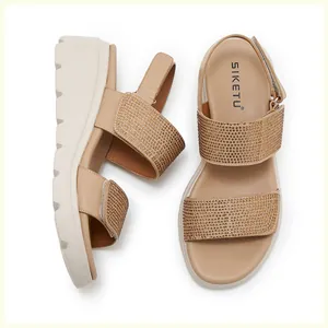 Detail of rhinestone embellished wide straps on beige wedge sandals with thick soles
